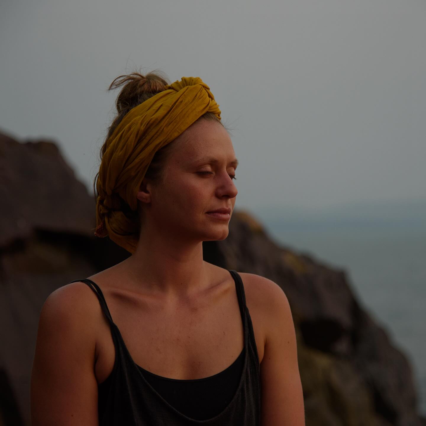 Elli Weis, co-founder of Mani Yoga, standing outdoors at dusk