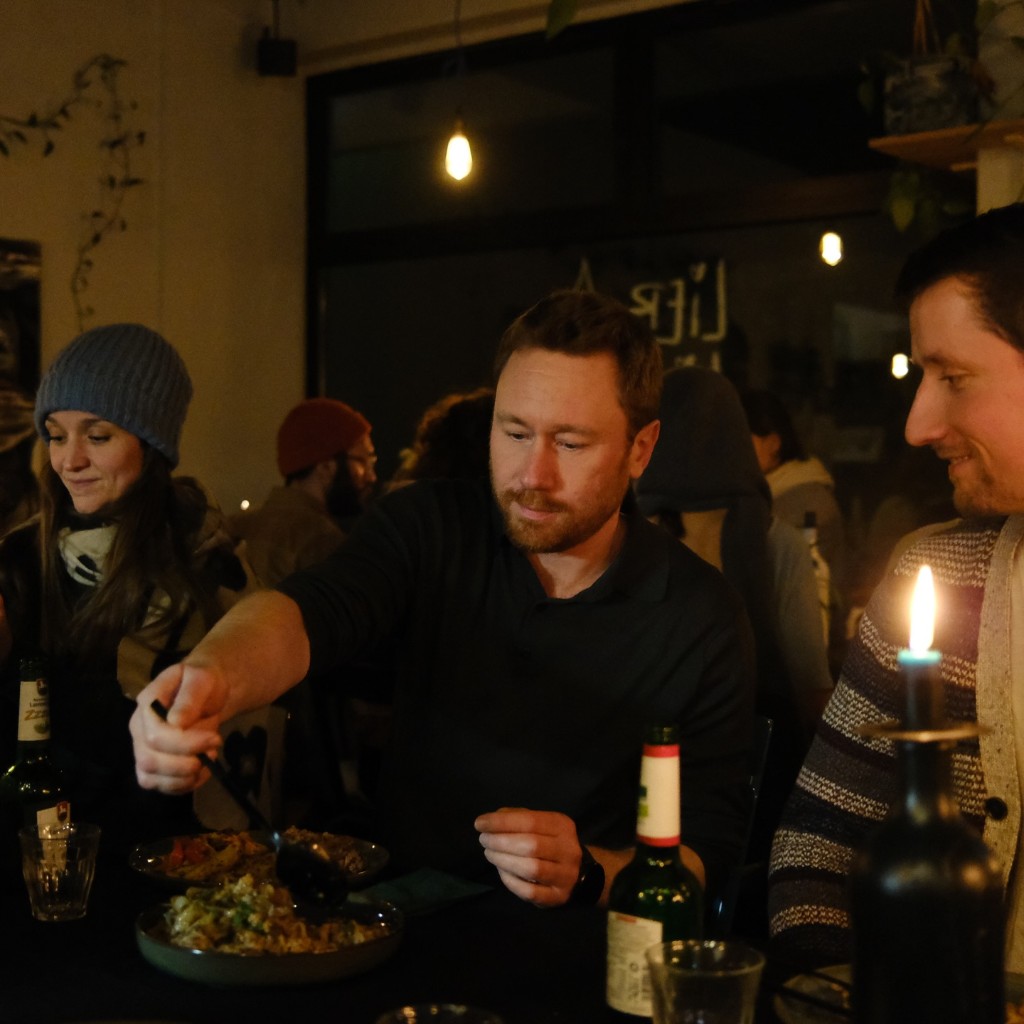 A warm community dinner in soft candlelight
