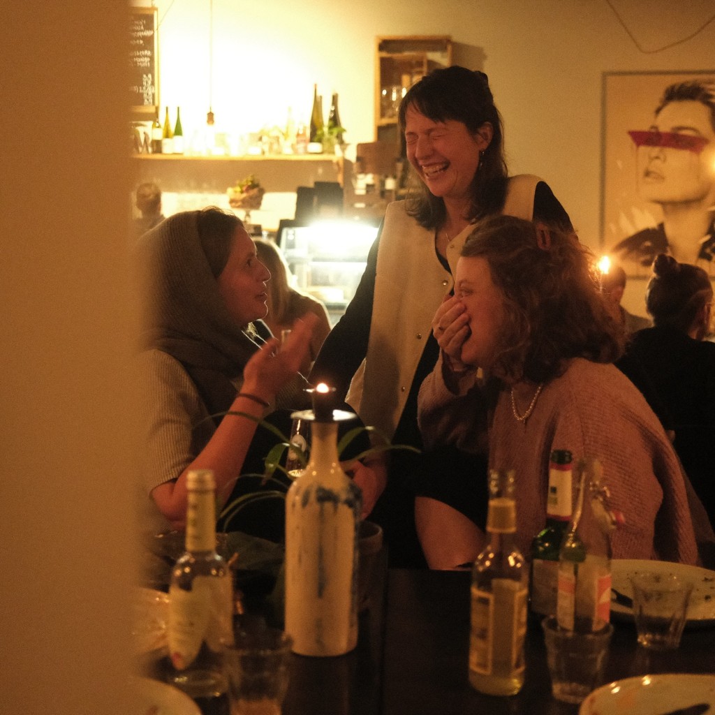Friends laughing together over a candlelit dinner