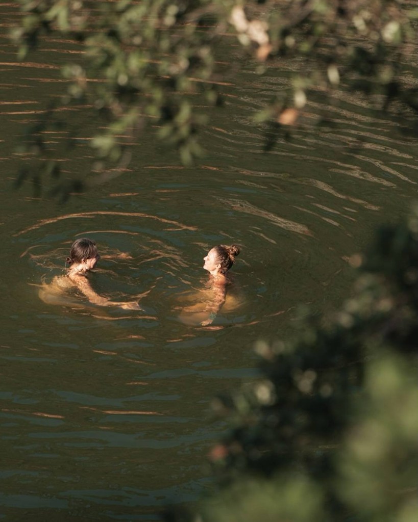 Two women swimming in a calm natural pool